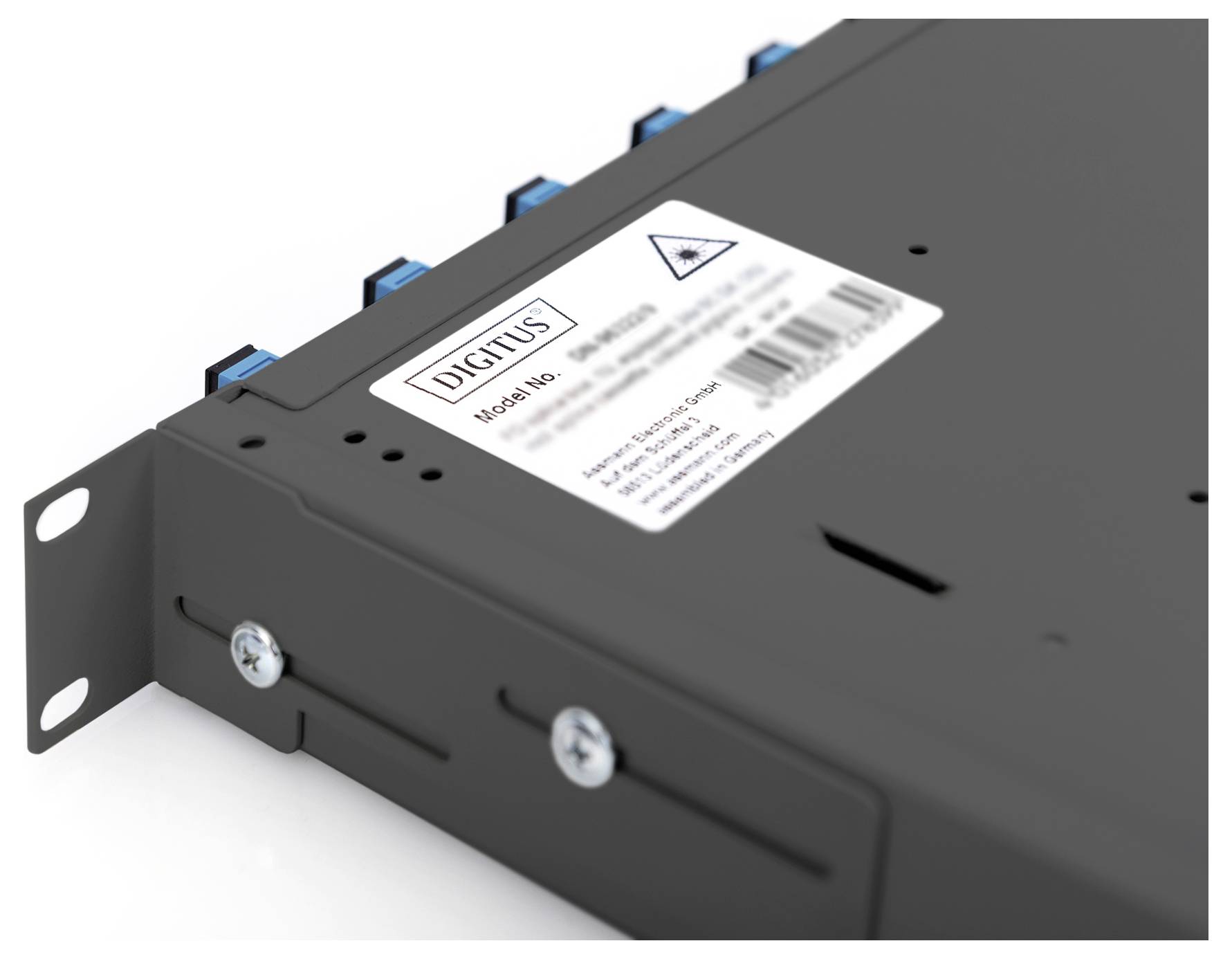 A grey metal enclosure with several blue connectors on top and a white label with a barcode and warning notice on the upper surface.