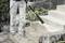 A person is cleaning an exterior staircase with a pressure washer; the water jet is removing dirt from stone steps.