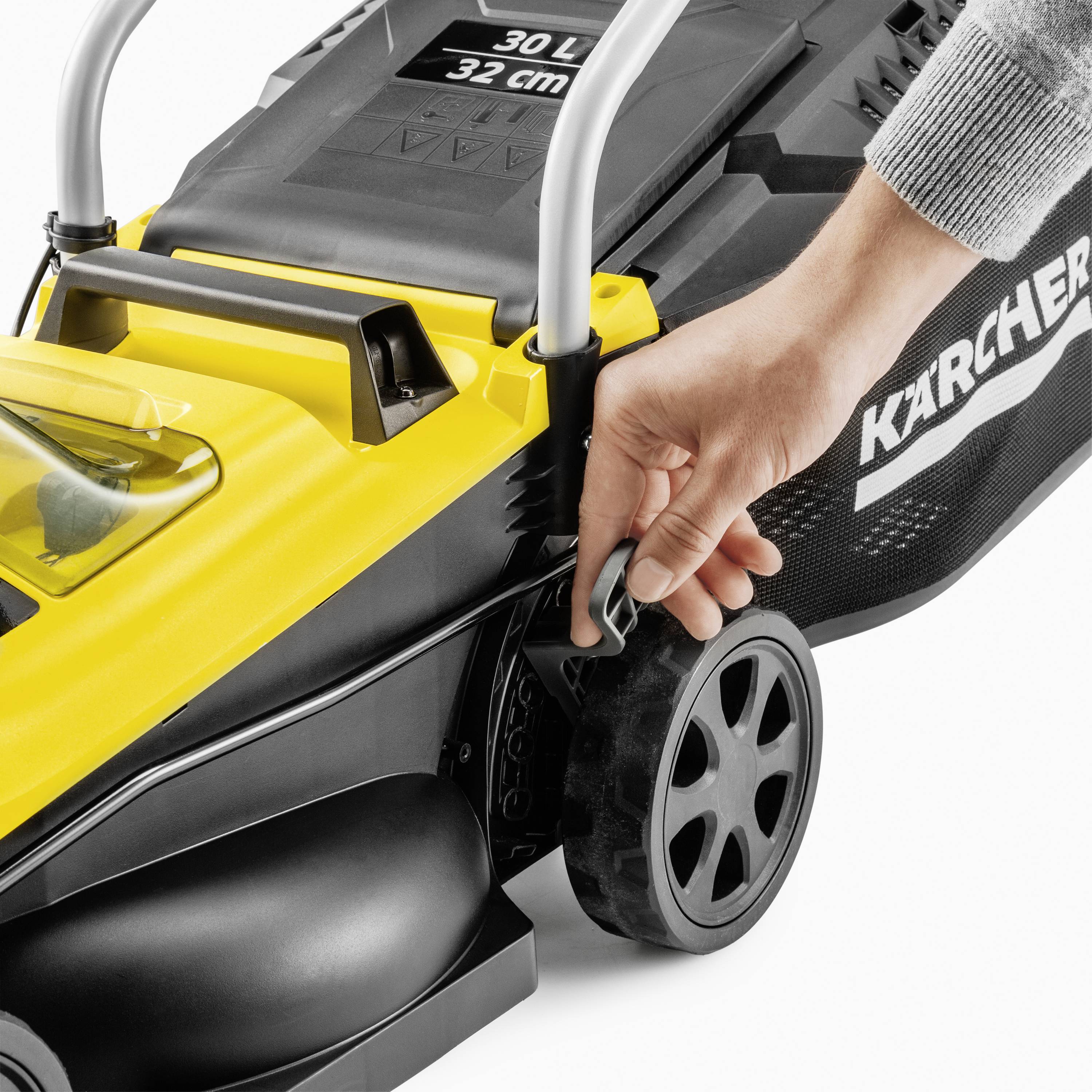 Someone has their hand on a yellow lawnmower, with its handle visible. The lawnmower has a '30 L' capacity label.