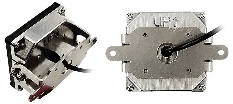 Two views of a metal connector piece with the inscription 'UP' and an upward-pointing arrow. A cable is connected to the connector.