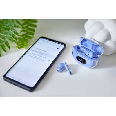 A smartphone next to blue wireless earbuds protruding from an open case. A green plant is in the background.
