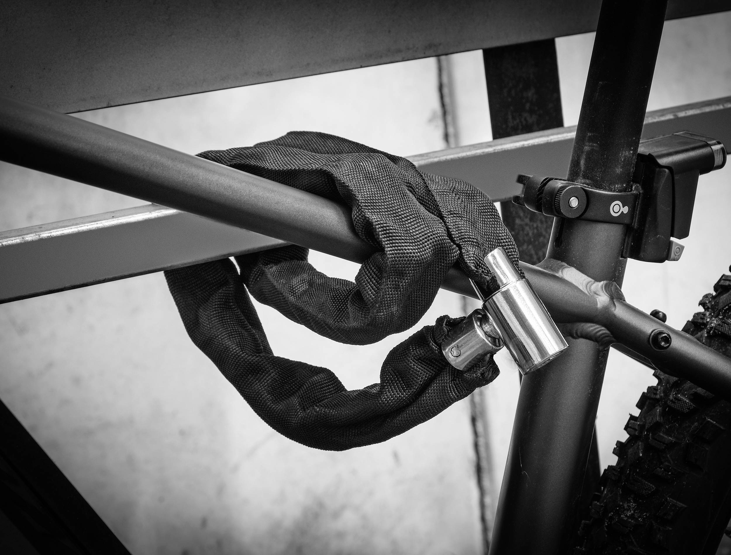 A bicycle is secured to a rack with a chain lock.