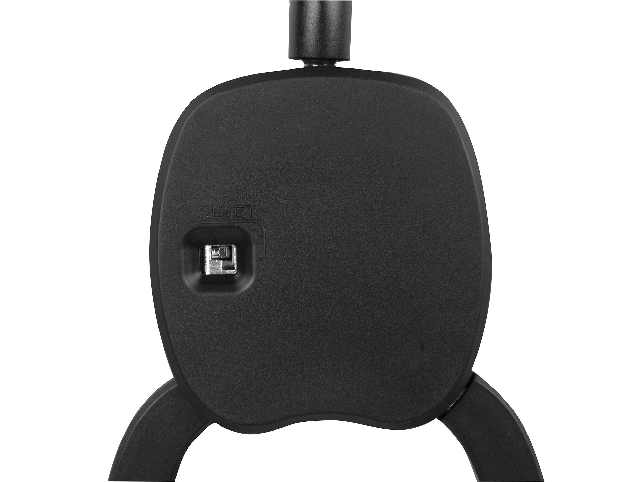 Reset button on the underside of a black device, possibly a headphone or headset.