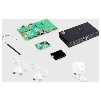 Various electronic components on a table: circuit board, black casing, aerial, adaptor and cables.
