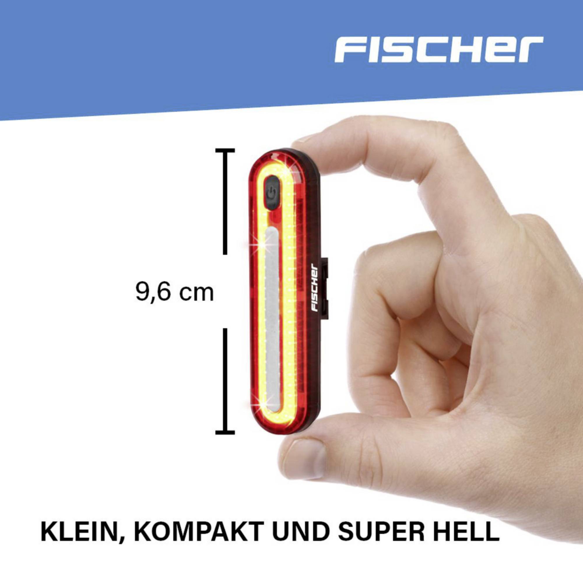 A hand is holding a compact, 9.6 cm sized, red rear light. Text at the top: 'Fischer'. At the bottom: 'Small, compact and super bright'.