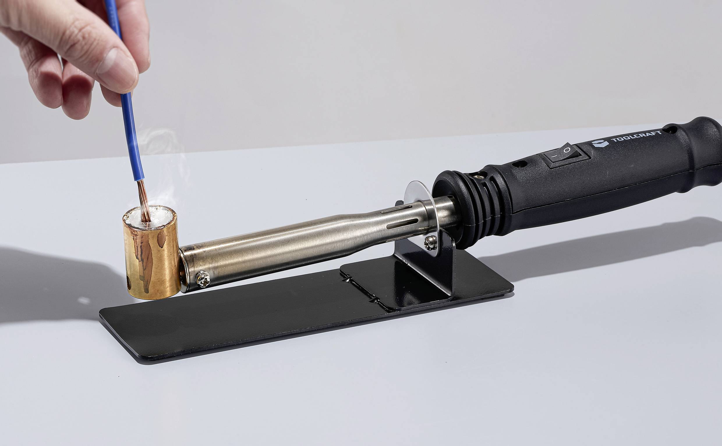 A Wax Seal Kit: A heated melting spoon, attached to an electric seal tool, with a hand pouring wax.