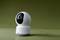 A white surveillance camera with a round, rotatable head on a green background.