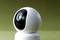 A modern surveillance camera with a spherical design, focused on the lens, against a green background.