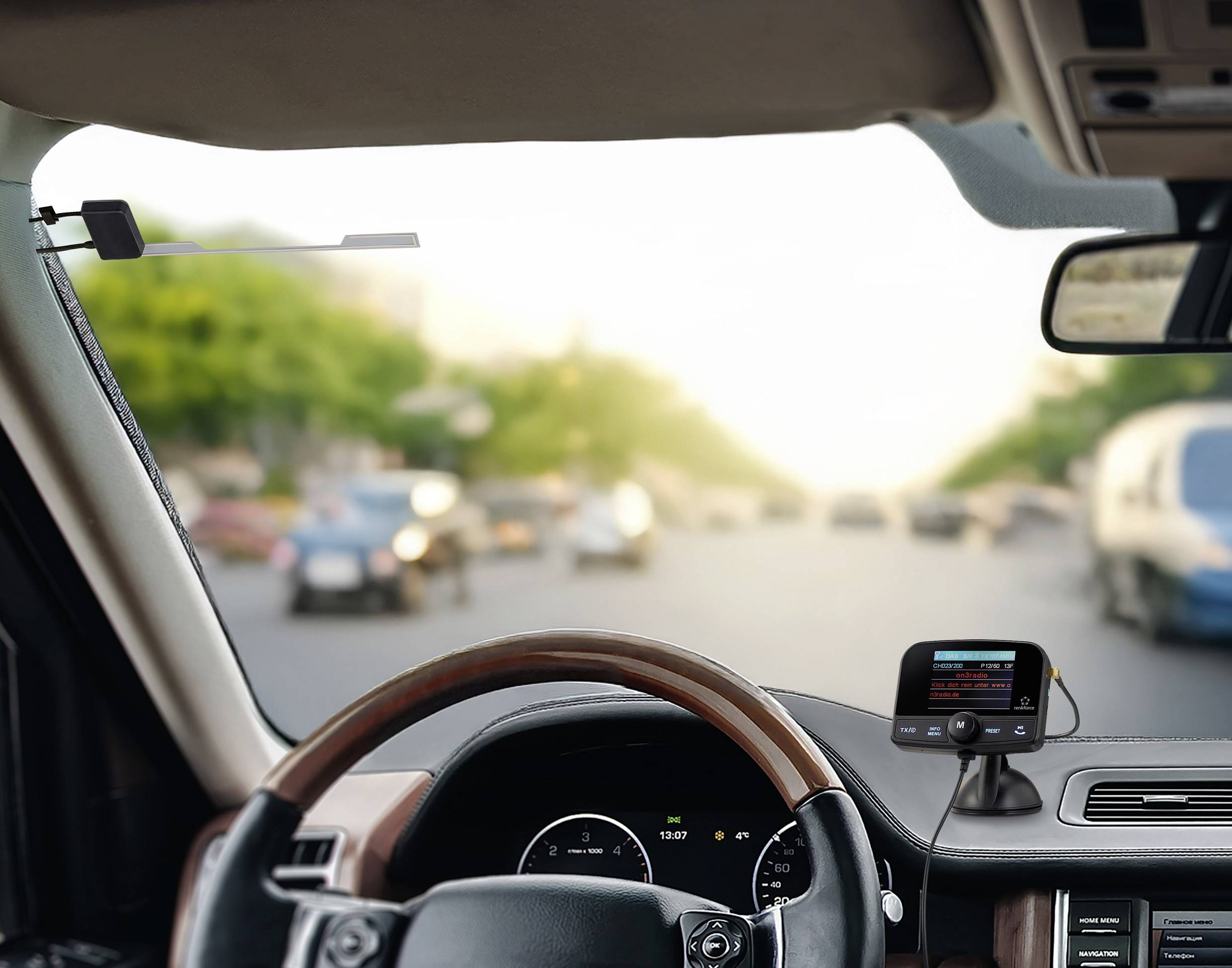 View through a car windscreen onto a bustling street. A satellite navigation device displays directions.