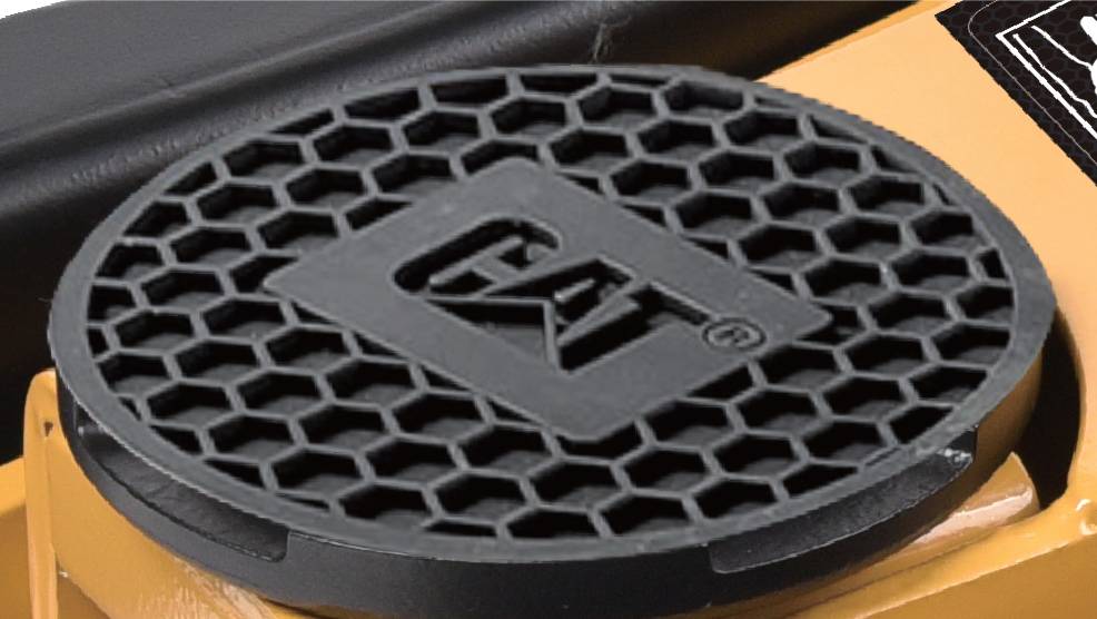 Close-up of a circular grill with a honeycomb pattern featuring the 'CAT' logo, part of a larger piece of machinery.