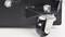 A close-up of a metal swivel caster attached to the corner of a black piece of equipment, highlighting the wheel and mounting bracket.