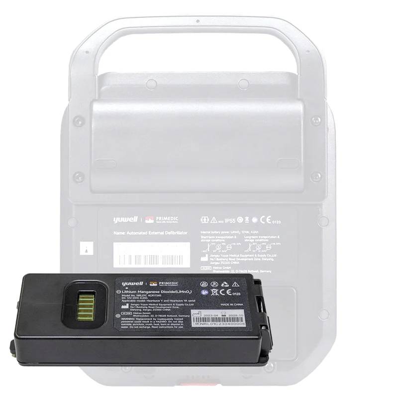 Portable defibrillator with battery removed, which is shown separately. The battery displays multiple symbols and technical information.