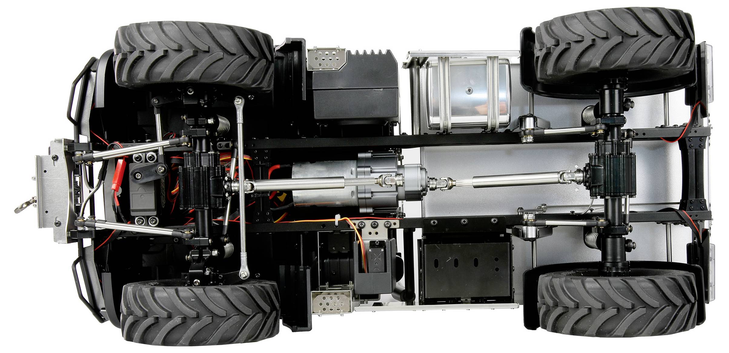 Underside view of a remote-controlled car, showing the chassis, large tyres, and visible engine and connecting components.