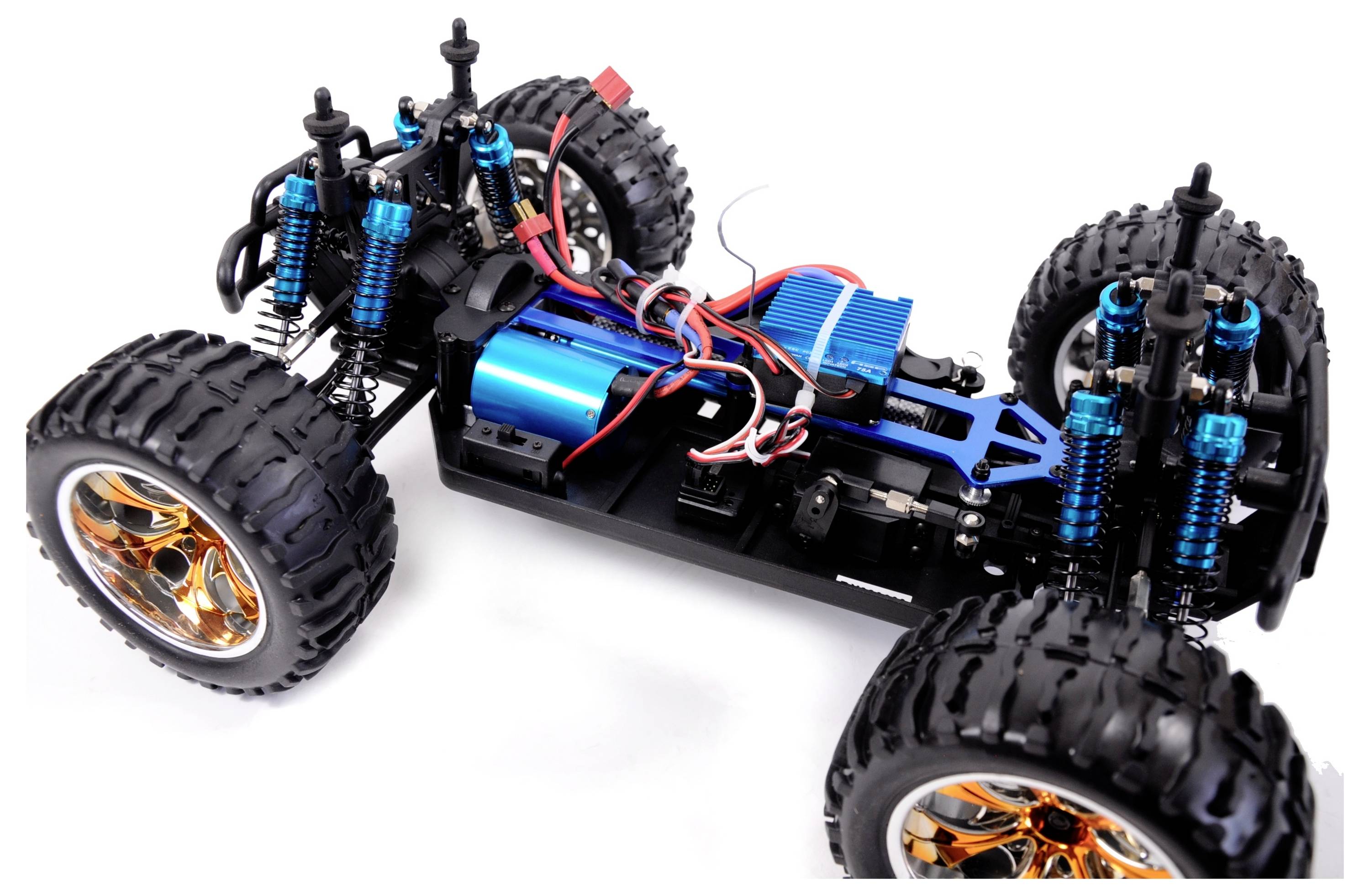 Remote-controlled car chassis in close-up with chunky off-road tyres, blue shock absorbers, and visible cables and motor.