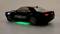 Black toy car with 'RACE' lettering, illuminated rear lights, green underbody lighting on a grey background.