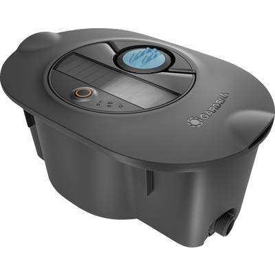The image shows a black Gardena-branded robotic lawnmower charging station with a control panel and a prominent blue button.