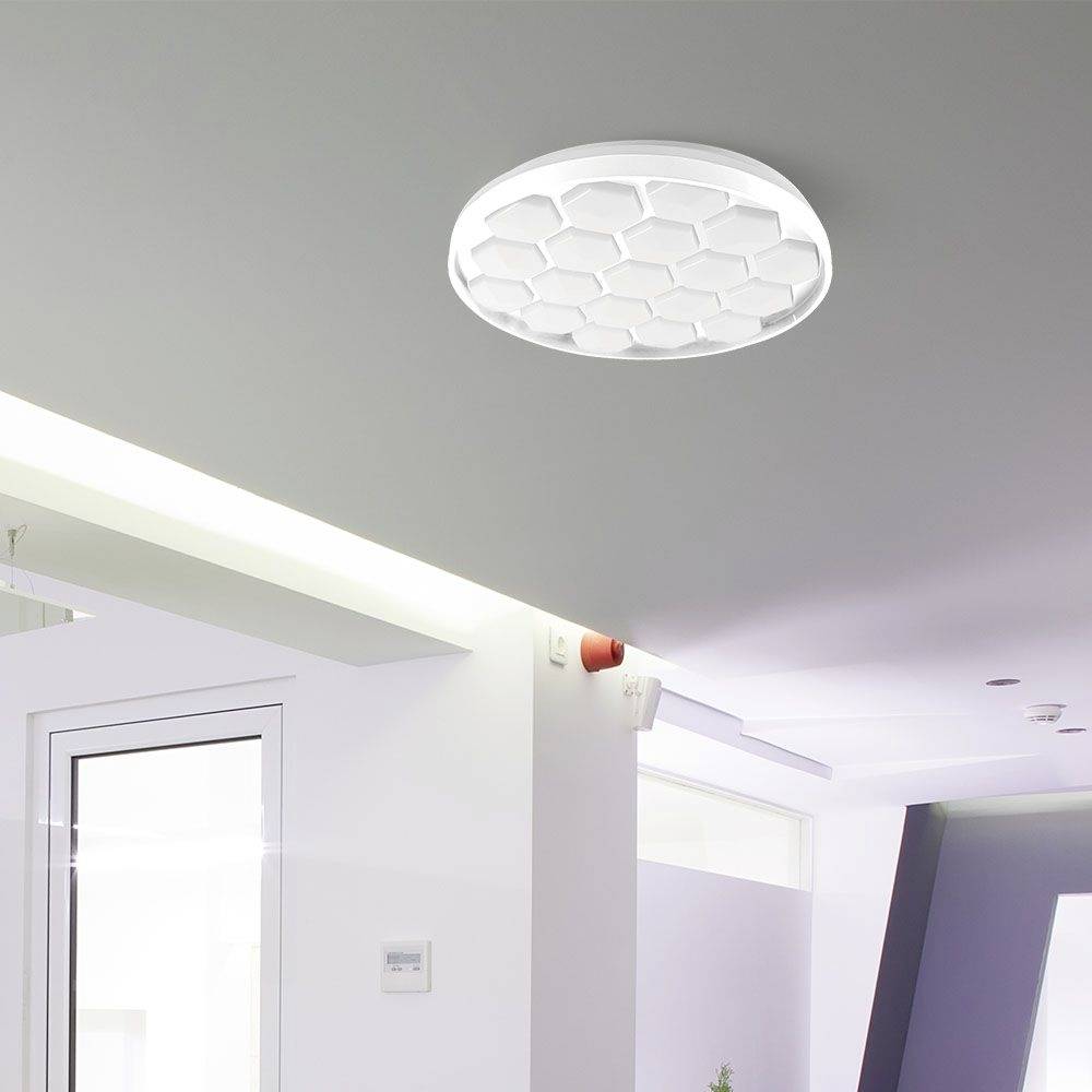 Round, white ceiling light with a honeycomb-like pattern, mounted on the ceiling of a modernly furnished room.<br><br>Round, white ceiling light with a honeycomb-like pattern, mounted on the ceiling of a contemporary interior.