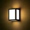 Wall lamp with a rectangular, modern design illuminates a textured wall in warm light.