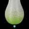 A vase with a pattern transitioning from white to light green, set against a black background. At the bottom, there is a round logo with "MAERTZ".