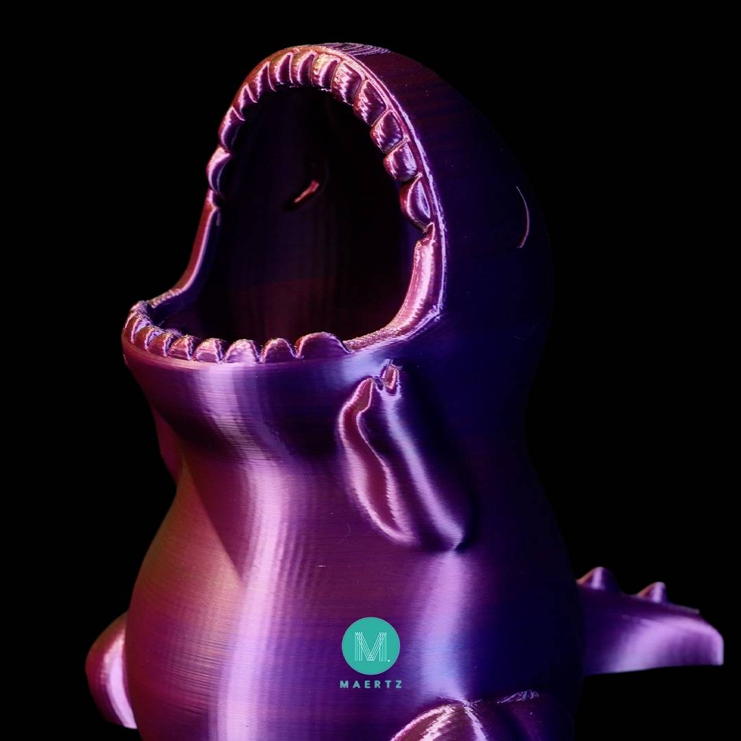 A purple shark model opens its jaws wide. It is an artwork with a metallic sheen.