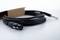 Black audio cable with an XLR plug and a 6.35 mm jack plug, partially lying in a brown packaging.