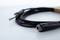A black audio cable with two connectors is lying on a light surface. The foreground shows a jack socket.