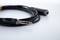 Black audio cable with a 6.35 mm jack plug and socket, lying on a white surface.