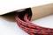 Red and black braided cable protruding from a brown envelope.