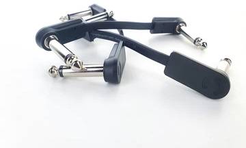 Two short guitar leads with angled jack plugs are lying on a white background. Ideal for connecting compact pedals on a pedalboard.
