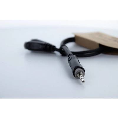 Audio cable with 3.5mm jack lying on a table, packaging in the background.