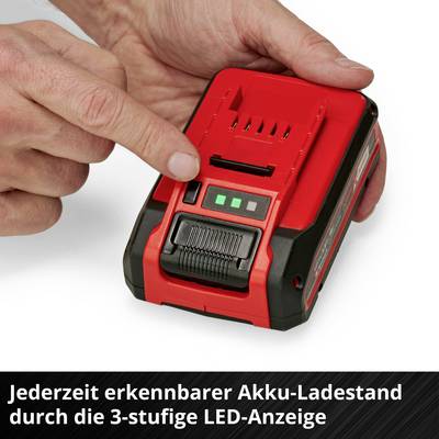 A hand points to a red, portable battery with three green LED lights indicating the charge status.