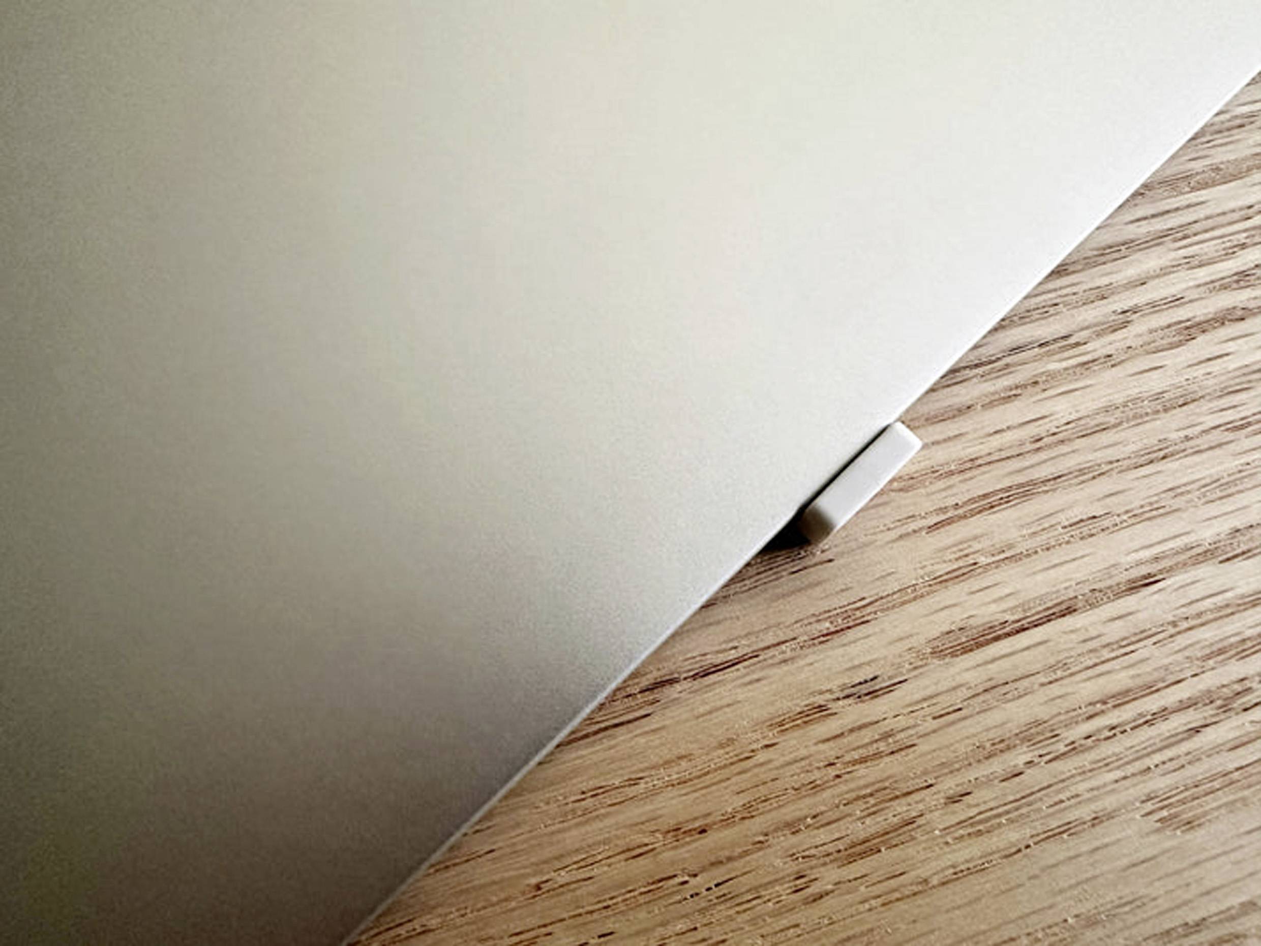 Laptop on a wooden table, corner visible.