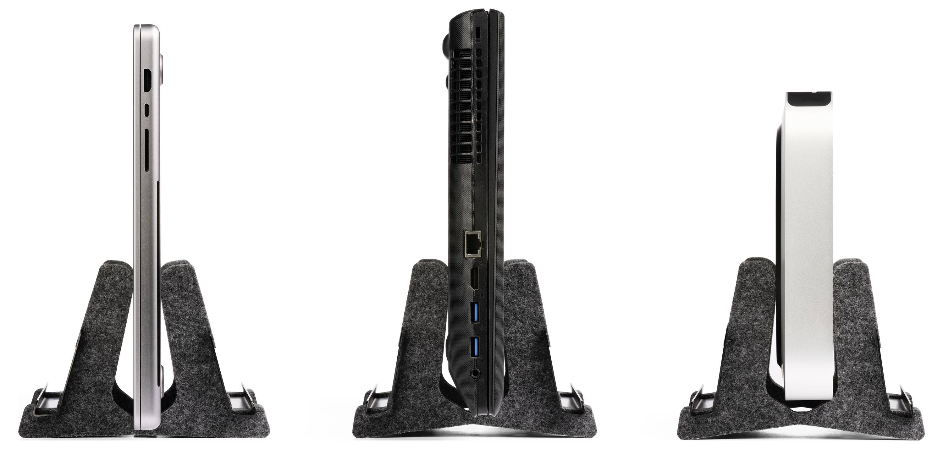 'Three laptops in vertical stands, from left: silver, black, white. Side view reveals different ports and designs.'