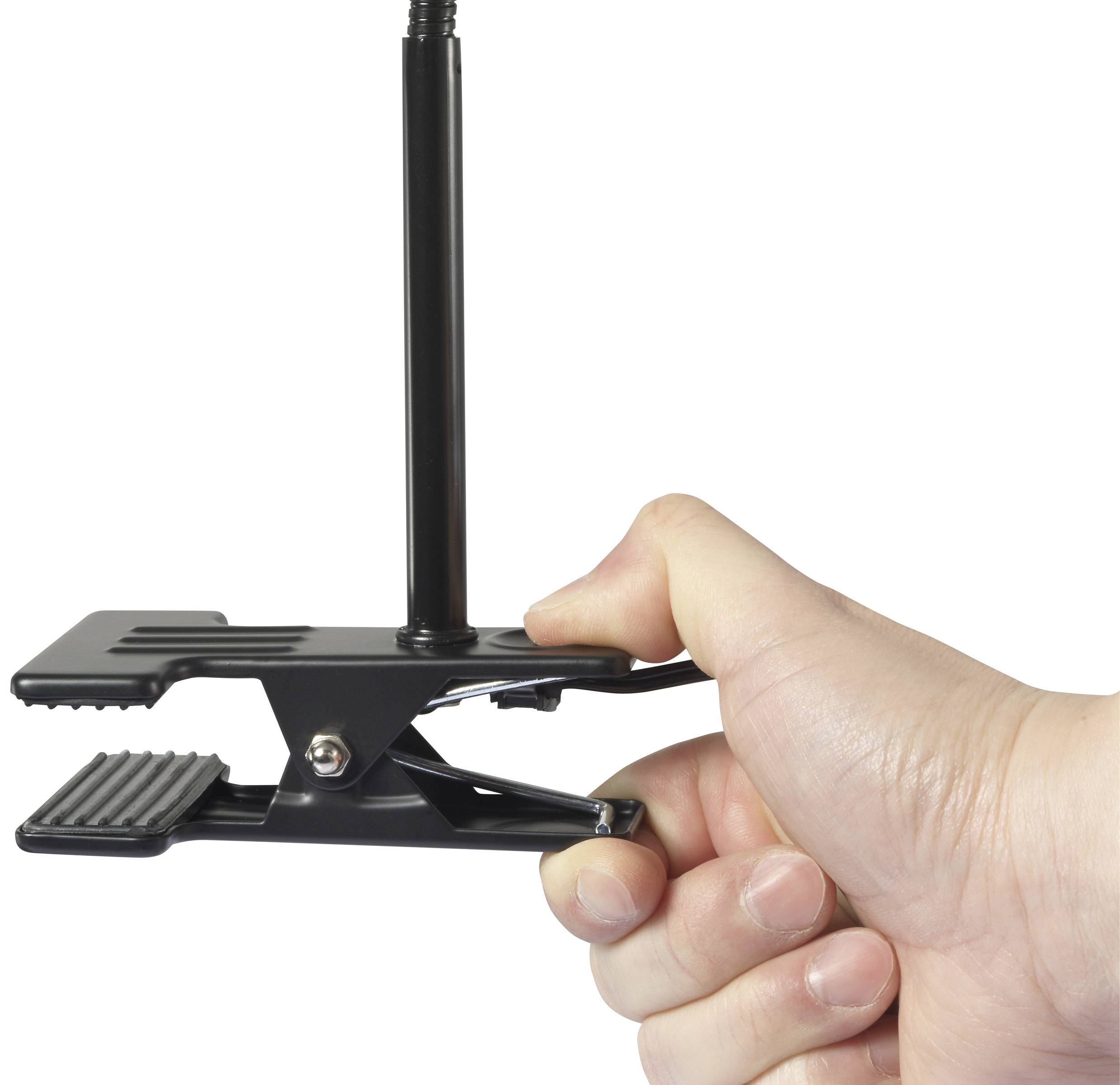 A hand is holding a small, black desk lamp with a clip and a swan neck design.