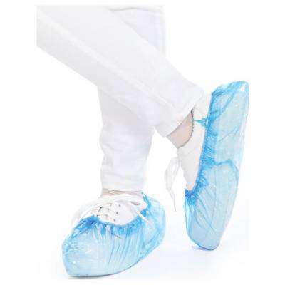 A person is wearing white shoes with blue overshoes, presumably to protect against dirt or contamination.