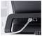 A white cable is plugged into the LAN port of a black monitor sitting on a desk.