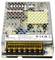 'Metallic power supply with six terminal connectors and markings for model, input, and output specifications on a label.'