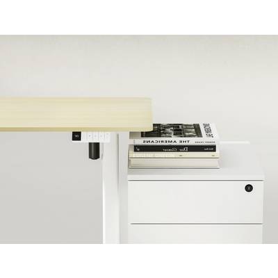 An adjustable desk beside a white cabinet with two stacked books on the work surface.