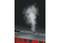 Red train with steam billowing from its roof, against a black background.