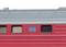 Close-up of a red train carriage with a blue sign and windows. The image depicts details of a modern train facade.