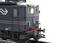 Close-up of a dark model locomotive on tracks, with distinctive headlamps and detailed metallic structures.