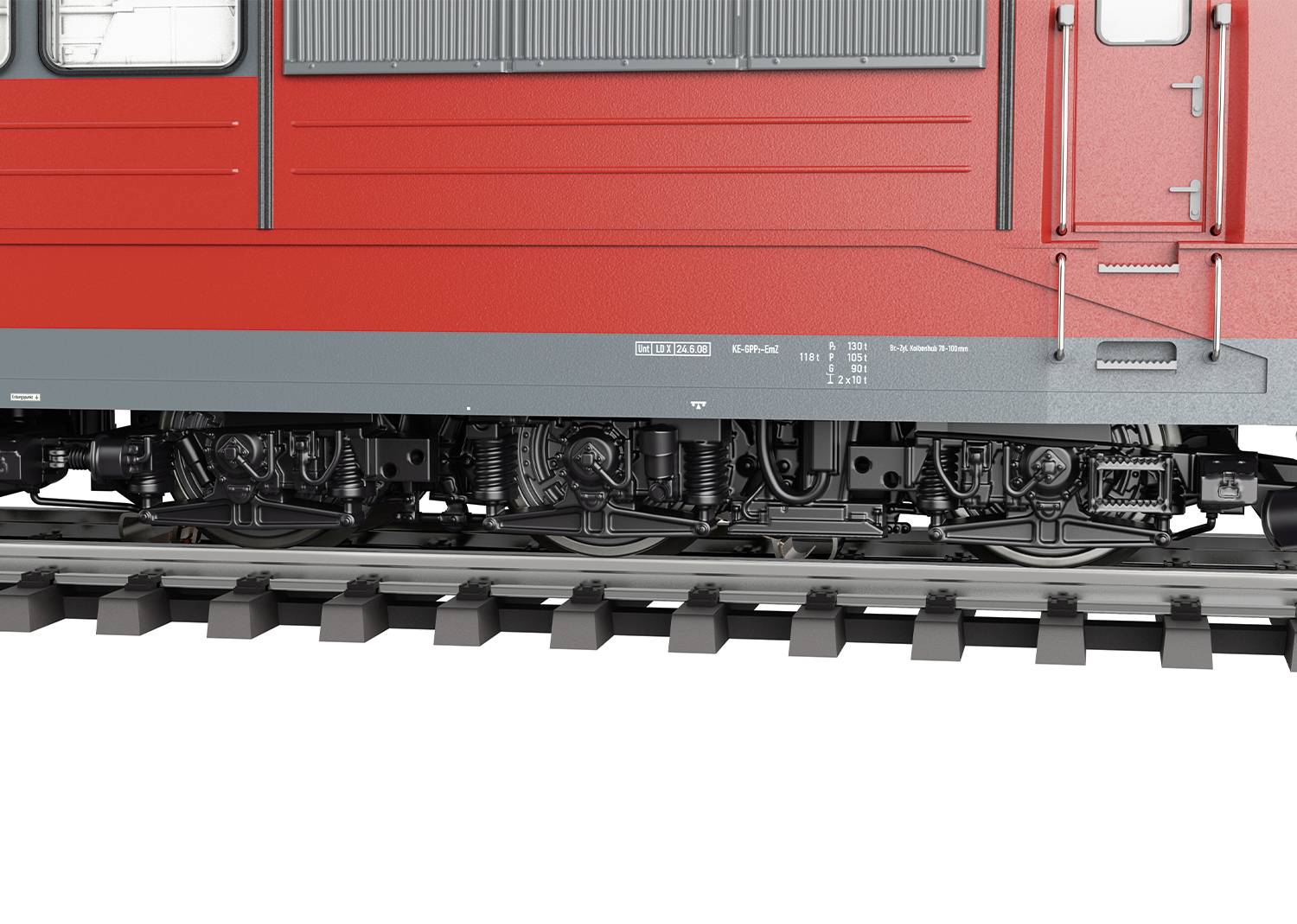 A red train on railway tracks, close-up of the undercarriage. Suspension and wheel details are visible. No people or landscape present.
