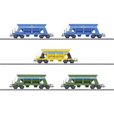 Five model freight trains in blue, yellow, and green colours on railway tracks, each labelled with different numbering.
