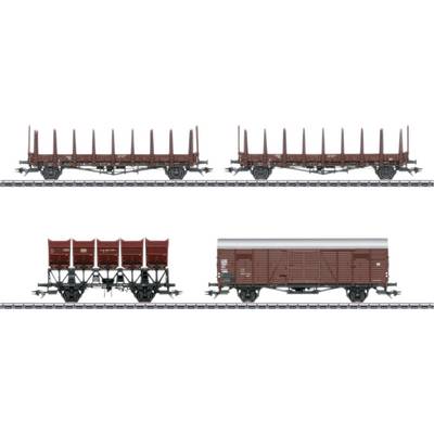 An illustration of four different model railway wagons on tracks: two open freight wagons, a covered goods wagon, and a timber transport wagon.