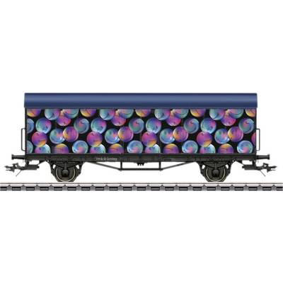 A goods wagon with a black body, printed with colourful, neon-coloured, spherical patterns.