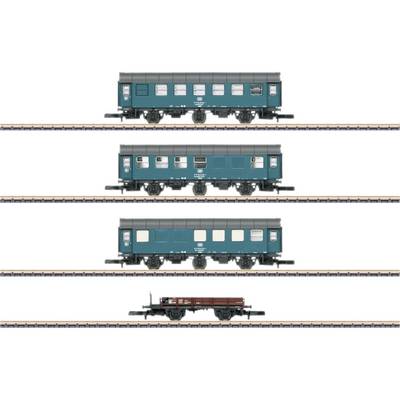 Four model railway carriages on tracks: three green passenger train carriages and a brown goods wagon in a row.