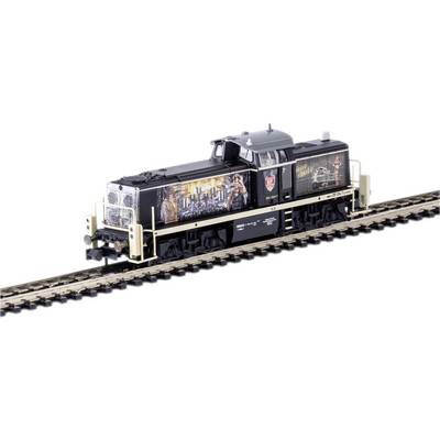 A model train on a track. The train has intricate graphics on the side and details in black and beige.