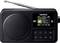 Black DAB+ radio with display, showing the radio station '1LIVE diGGi'. Speakers on the left, buttons and display with antenna on the right.