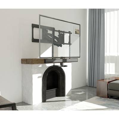 A flat-screen television is mounted on a wall bracket above an unused fireplace. A sofa is positioned to the right of the image.