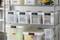 Metal shelving units with transparent plastic boxes labelled 'Cables', 'Electronics', 'Tools' and more for organised storage.